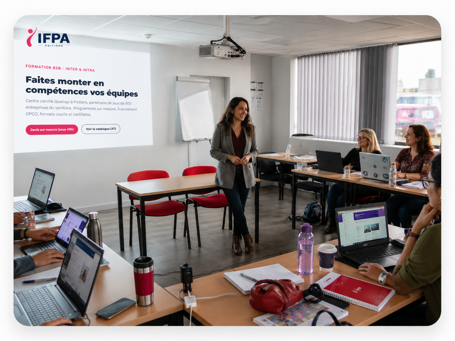Formation B2B à l'IFPA Poitiers — formatrice animant une session intra-entreprise face à un groupe de collaborateurs en présentiel, projection visible 'Faites monter en compétences vos équipes'