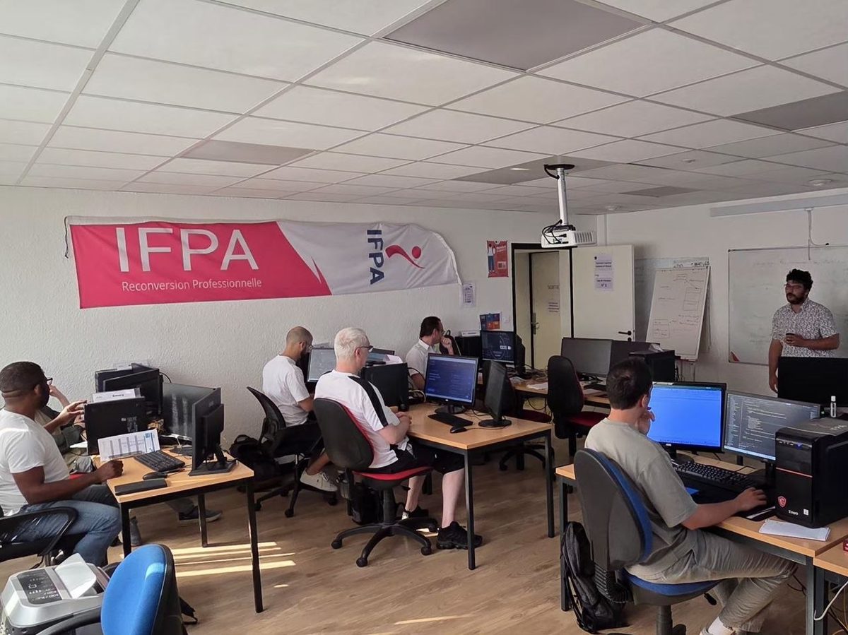 Promotion TSSR de l'IFPA Poitiers — apprenants en formation systèmes et réseaux sur postes multi-écrans, formateur en présentation